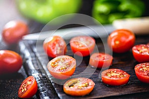 Sliced Ã¢â¬â¹Ã¢â¬â¹red tomato to be used as a culinary ingredient on rustic wooden cutting board, vegan and organic cuisine photo